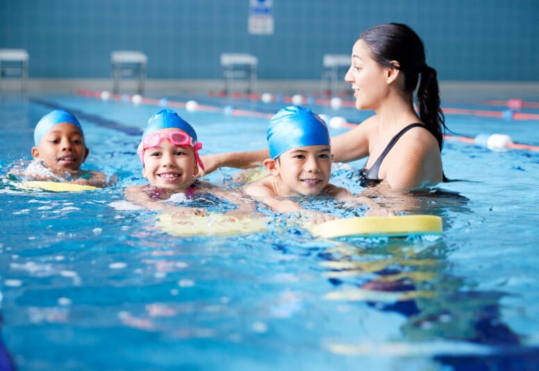Children learning to swim with instructor.